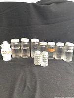 Group shot of milk-glass vanity jar, seven spice jars, two salt/pepper shakers