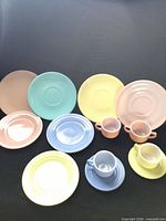 Full group of pastel melamine cups, saucers and plates including four larger Lournay Melmac plates