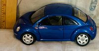 Left side profile of blue 1998 Beetle model showing wheels and body