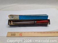 Sharpening stone in tray with outer sleeve and ruler for scale