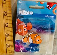 Front view of packaged Nemo figurine with ruler for scale