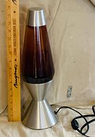Full view of lava lamp beside ruler showing height and power cord