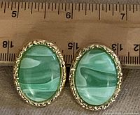 Front view showing green cabochons and gold-tone rope border