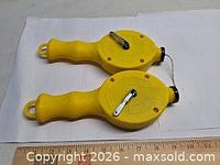 Two yellow Longo string line reels with handles and metal winding cranks