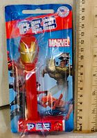 Front of sealed Marvel PEZ dispenser showing Iron Man head, candy packs and branding