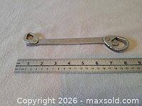 Overall view of multi-wrench next to ruler for scale