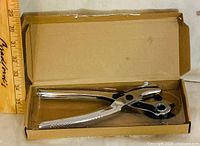 Leather hole punch in opened cardboard sleeve packaging