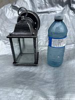 front view of lantern beside water bottle for scale