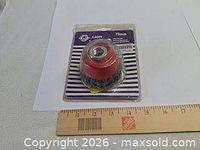 Front view of sealed Lion 75 mm wire cup brush package beside ruler for scale