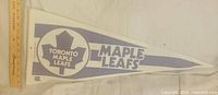 Front of white felt pennant with blue Toronto Maple Leafs logo and text