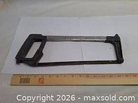 Full view of Powerfist hacksaw beside ruler showing length