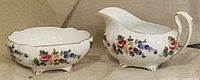 Front view of creamer and sugar bowl showing floral pattern and feet