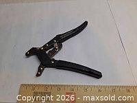 Overall view of self-adjusting pliers with ruler for scale