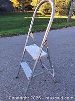 step stool opened showing two treads and curved handle