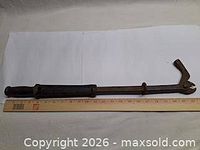 Full view showing entire nail puller next to ruler for scale