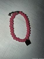 Top view of full bracelet showing beads, clasp and square logo charm