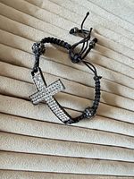 Full view of bracelet showing crystal cross and cord construction