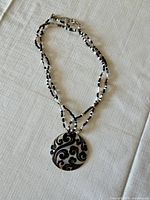 Full view of double-strand necklace with shell pendant