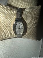 Front close-up of watch on cushion showing dial and case