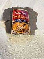 Front view of enamel pin showing full Campbell’s label artwork