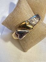 Front view of bracelet showing gold and silver tone hearts and scroll pattern