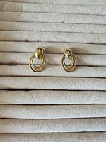 front view of earrings on display pad