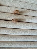 Front view of both gold-tone rhinestone half-hoop earrings