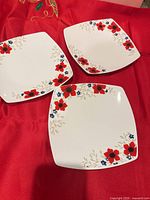 Three square plates face up showing floral borders
