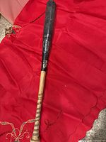 Full view of Louisville Slugger bat on red cloth