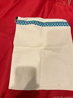 Full view of cream dust bag against red background showing overall shape