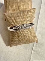 Front view showing pavé diamond panel on silver-tone bangle