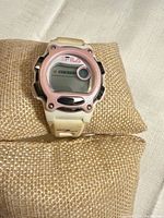 Front view of Fila digital sports watch showing white case, pink bezel, digital display