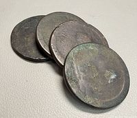 Four bronze coins stacked showing size and patina