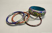 Five cloisonné bangles arranged on surface