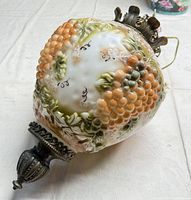 Full view of glass grape motif body and metal top