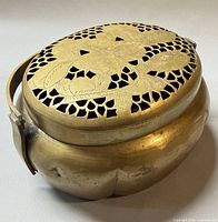 Top view showing pierced floral brass lid and overall form