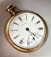Front view of Waltham pocket watch showing dial and gold-tone case