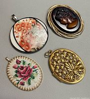 Group shot of all four pendants showing designs and relative sizes