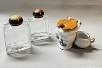 Overall view of two glass bottles and porcelain toilet condiment set