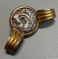Front view of coin brooch showing Greek profile and gold-tone bars