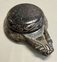 Top view showing lid with hexagonal pattern and beast head detail