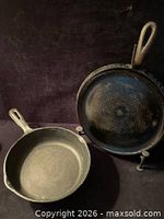 Both skillets resting on trivet showing overall lot