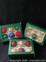 Three boxed sets of glass ornaments: multicolor matte, clear iridescent, red/white with stars