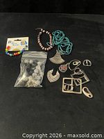 Full lot overview showing beads, pendants, buckles, bracelets, bead bag