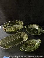 Four green pressed glass serving pieces displayed together