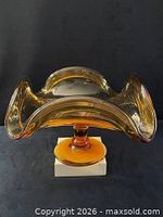 Front view of amber glass compote showing wavy rim and pedestal