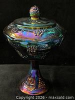 Full view of iridescent carnival glass covered compote showing grapevine pattern and pedestal