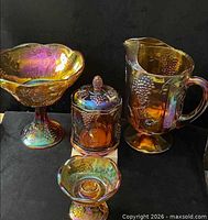 All four marigold carnival glass pieces grouped together