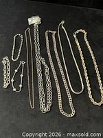 Group shot of all nine jewellery pieces laid flat on black background