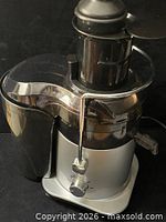 Front and side view of PowerXL juicer showing pulp container and spout